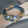 Bracelet femme sept cuirs ronds tons bleus et perles dorées et céramique