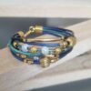 Bracelet femme sept cuirs ronds tons bleus et perles dorées et céramique